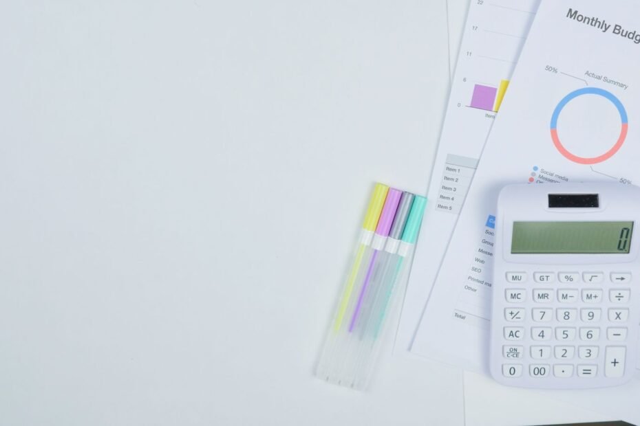 Calculadora e documentos de orçamento numa mesa organizada, ilustrando controle financeiro para freelancers