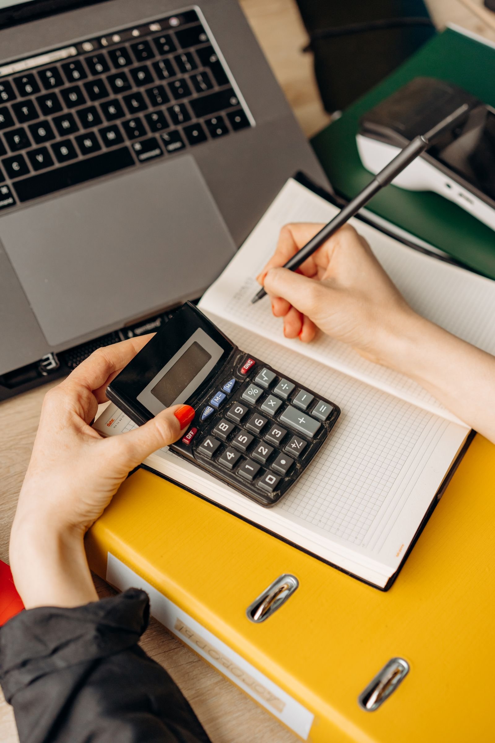 Planejamento financeiro com calculadora e laptop, imagem ilustrativa