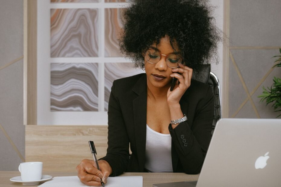 Vendedora ao telefone em sua mesa, exemplo de follow-up de vendas