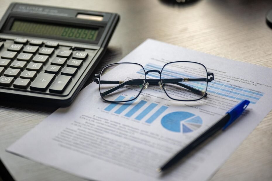 Calculadora e documentos financeiros numa mesa, ilustrando imposto de renda para autônomos e MEI