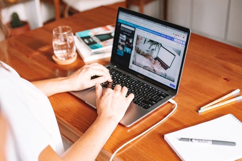 Pessoa usando laptop em mesa de madeira, ilustrando marketing de afiliados
