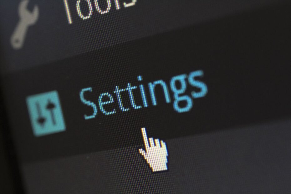 Cursor apontando para botão de configurações em tela de computador, ilustrando plugins essenciais para WordPress