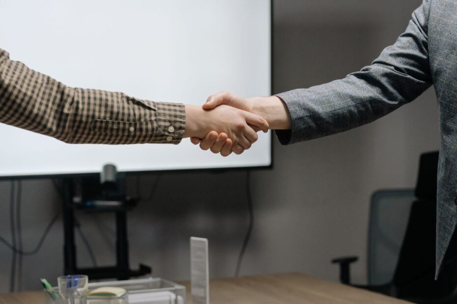 Profissionais selando acordo com aperto de mãos, exemplo de técnicas de negociação